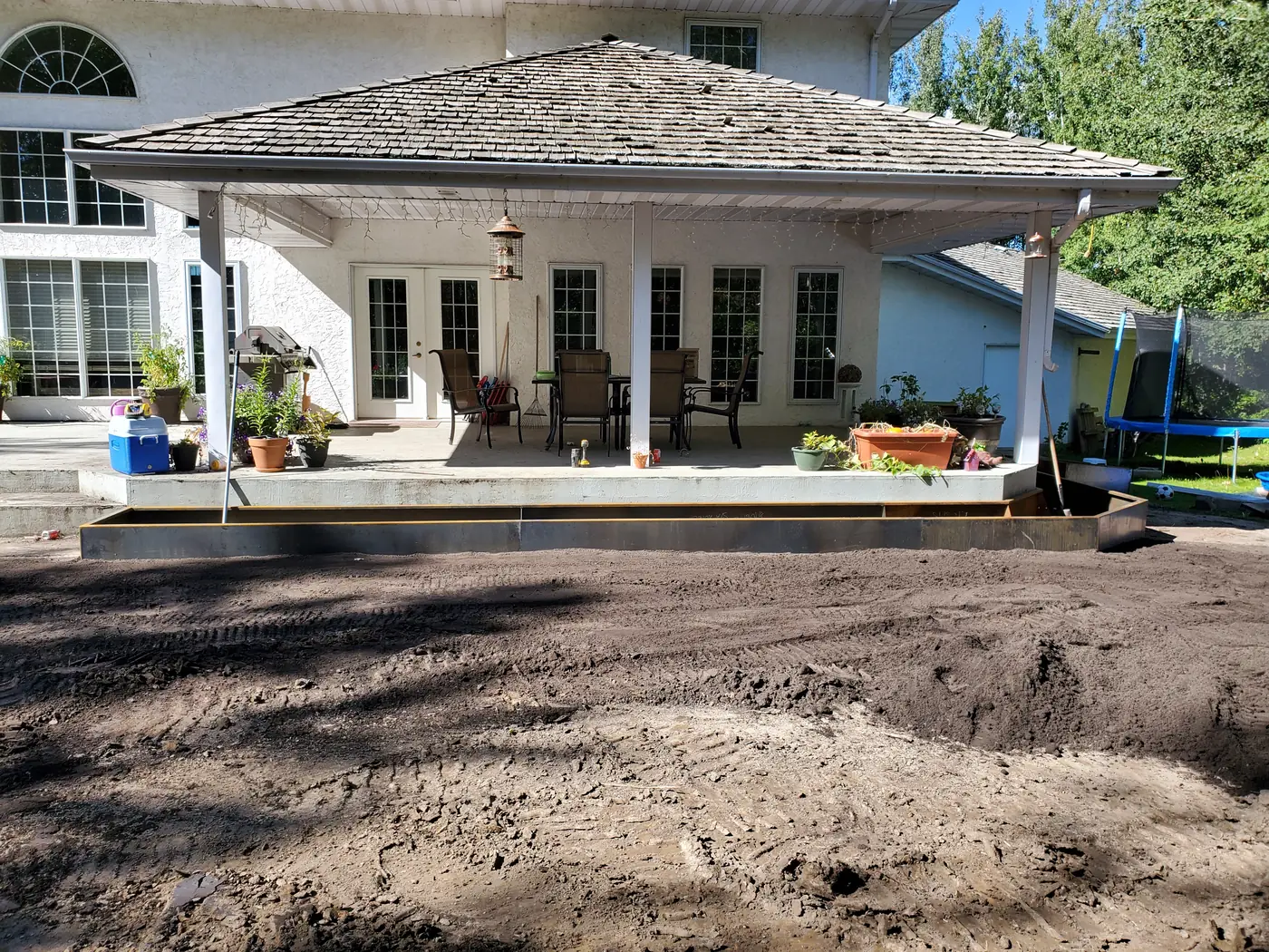 Wide view of a custom Corten steel backyard install along a covered patio