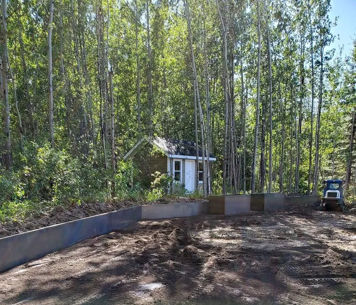 Long custom Corten steel retaining bed in a wooded backyard install