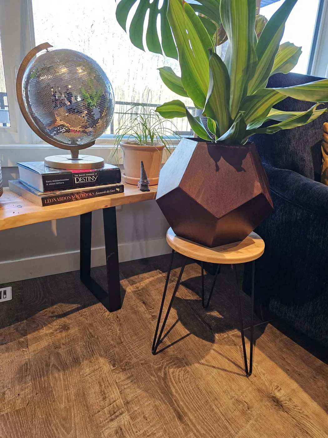 Faceted Corten steel planter on a hairpin stand in a sunlit living room