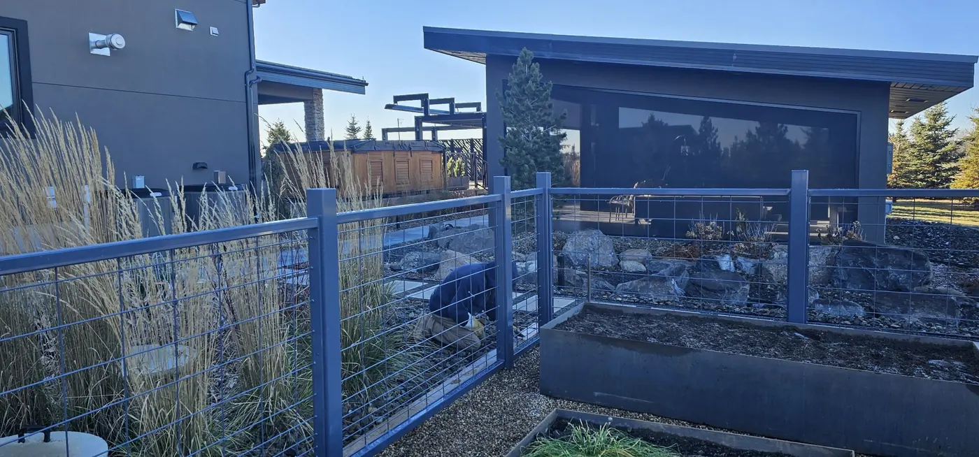 Steel frame and wire-mesh garden fence panels beside a modern home