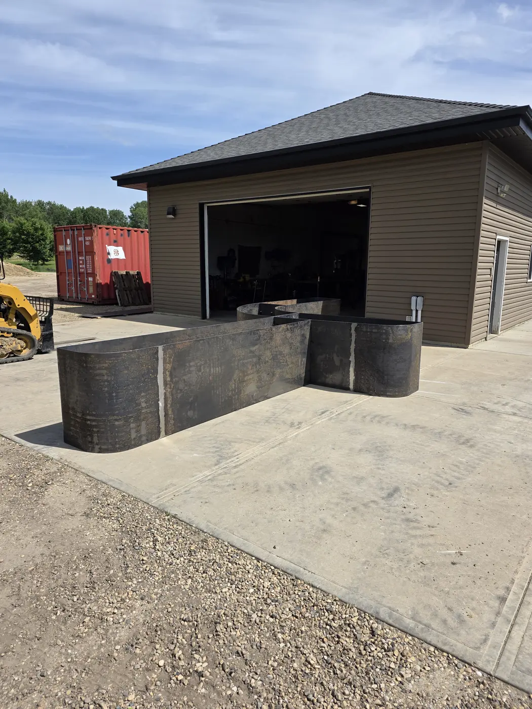 Serpentine Corten steel planter and bench modules outside the fabrication shop