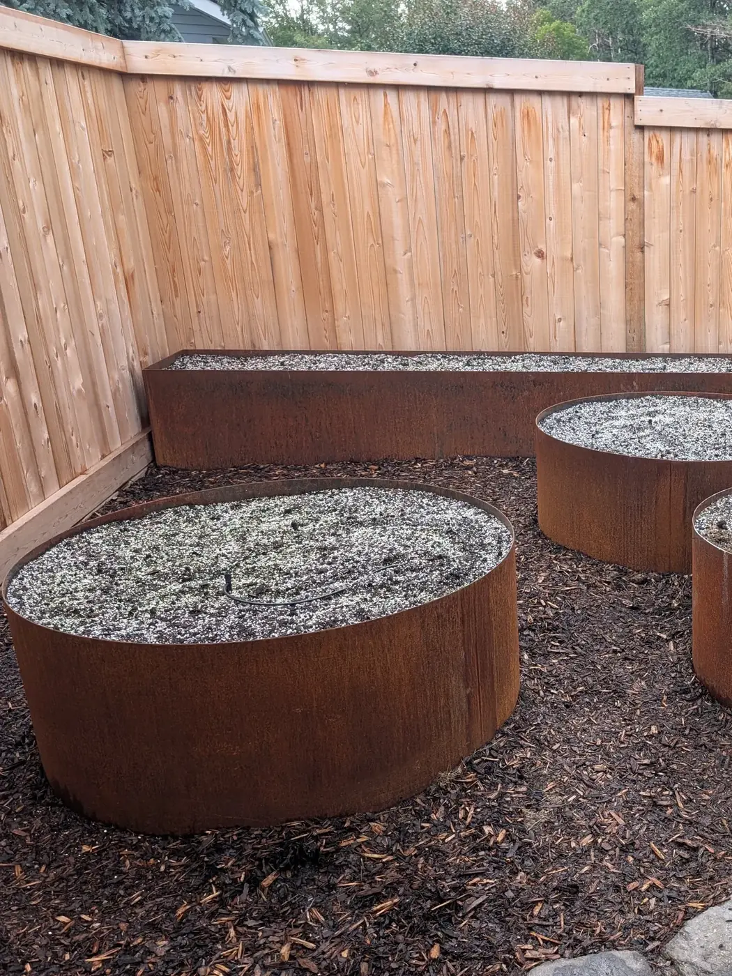 Detail of round Corten tub planters with weathered patina