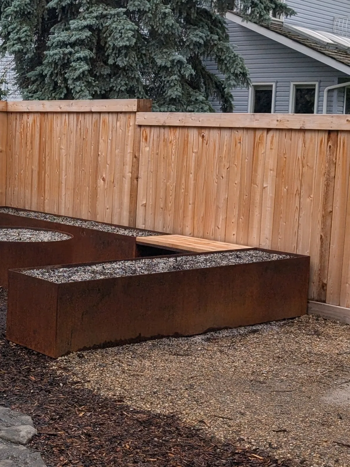 Integrated cedar bench between Corten trough planters