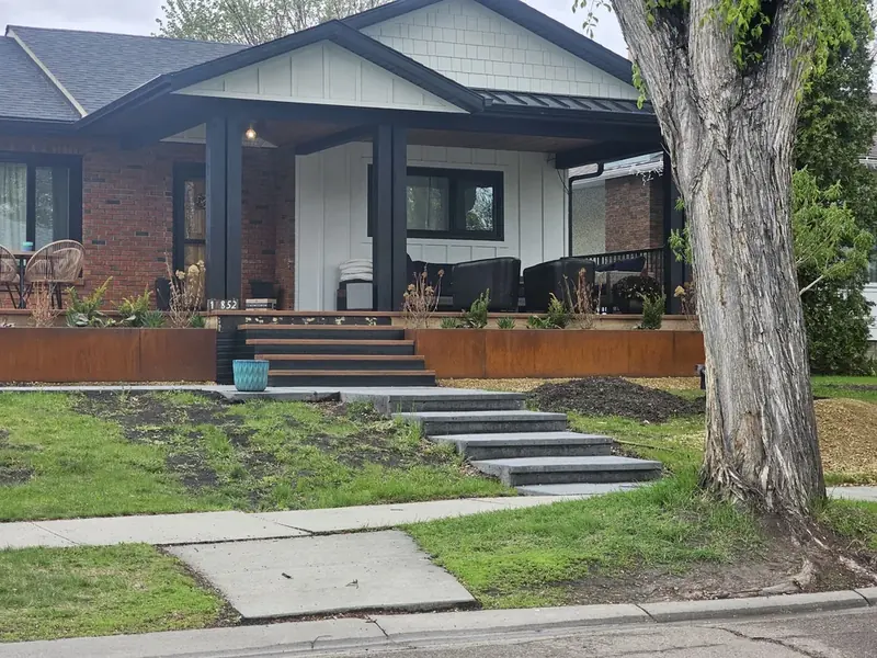 Corten steel planters wrapping the raised front porch of a renovated Edmonton bungalow