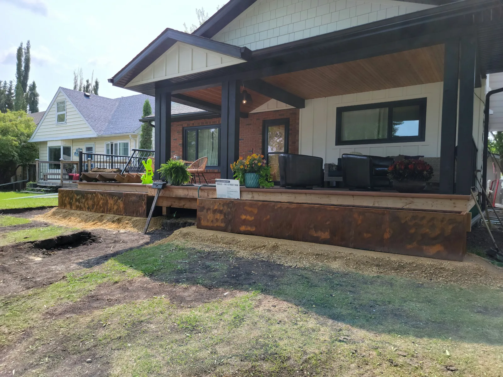 Wrap-around Corten porch planters with covered porch seating