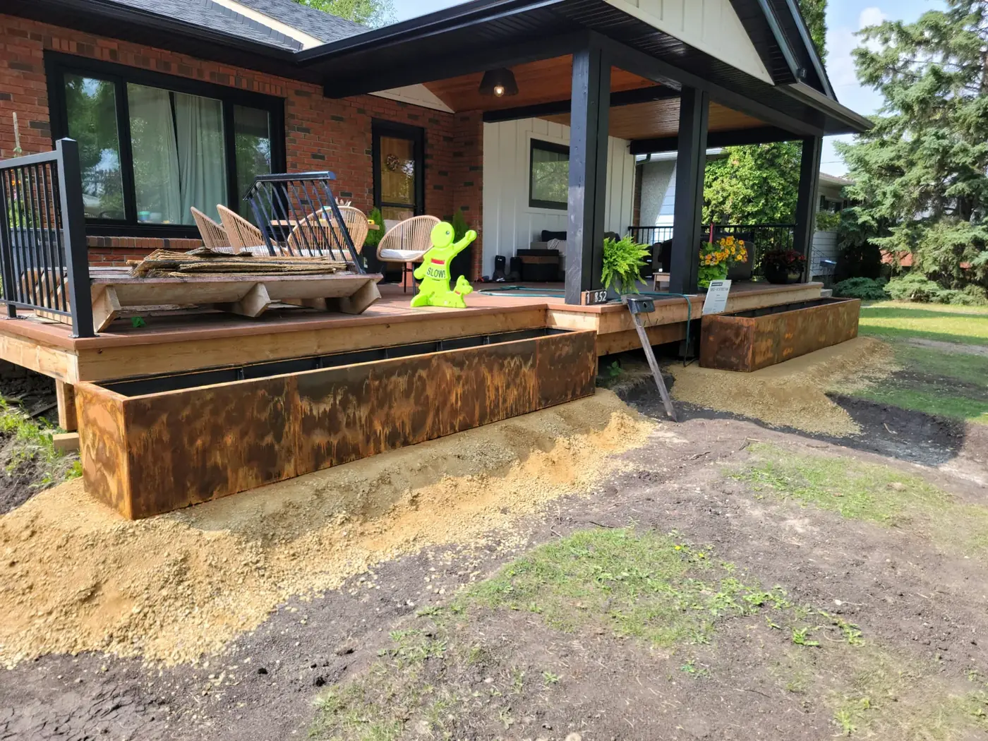 Corten weathering-steel planter boxes along the deck face