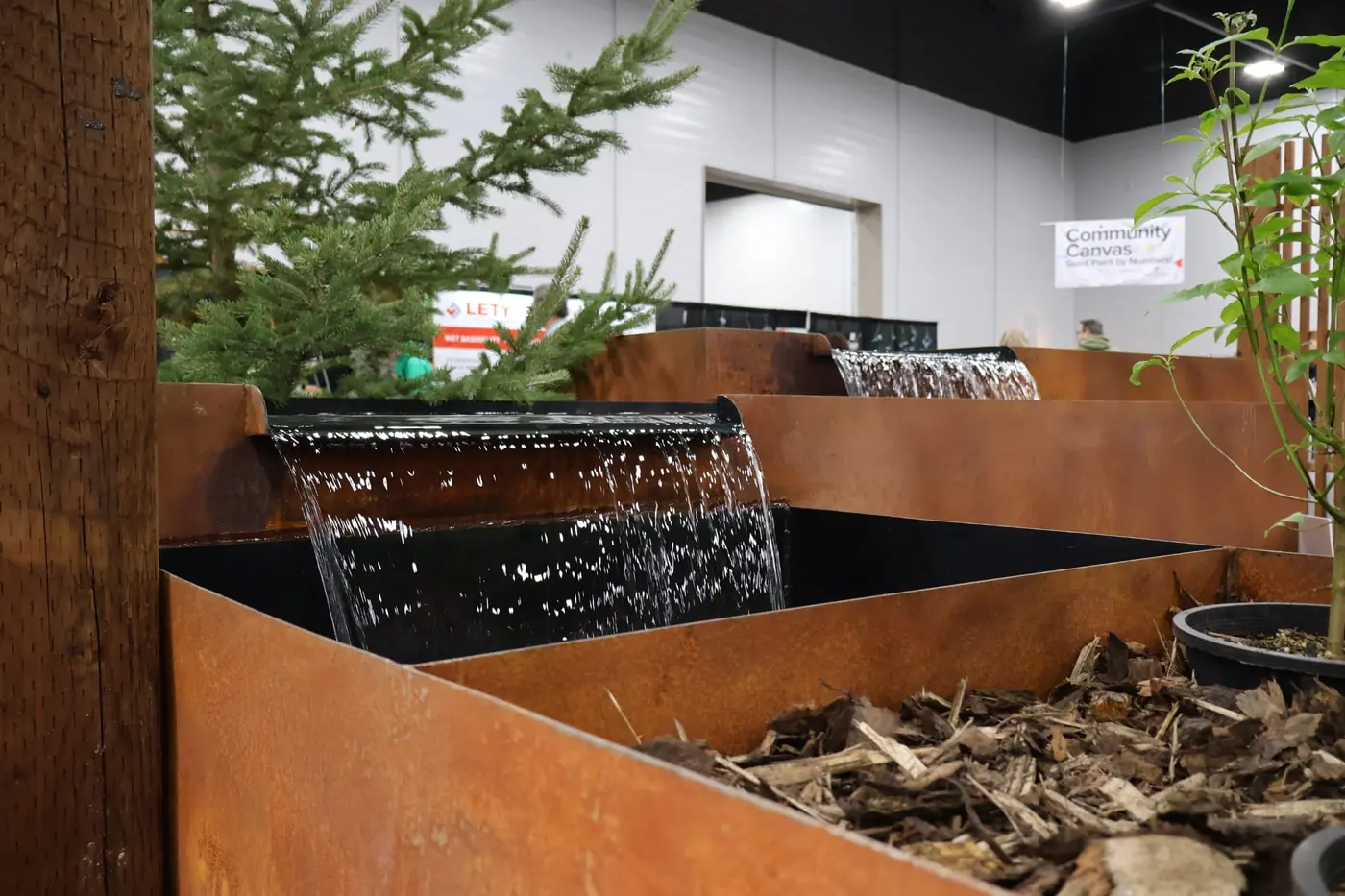 Two Corten steel water features with sheet-weir waterfalls at the show booth