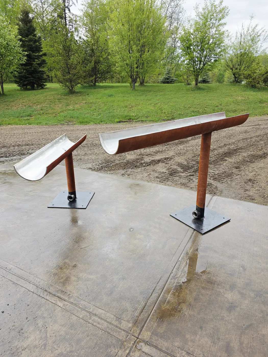Pair of Corten steel water-feature troughs at staggered heights on a concrete pad